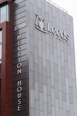 Leeds England: 4 Haziran 2024: Leeds Şehir Konseyi binası bulutlu bir gökyüzüne karşı ayakta duruyor ve kendine özgü mimarisini sergiliyor. Tabela konseyin adını ve amblemini açıkça gösteriyor..