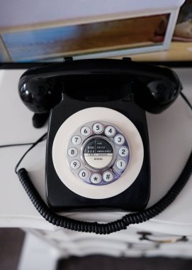 Durham UK: 19 Ekim 2024: Konforlu bir odada klasik tasarım ve işlevsellik sergileyen eski bir döner telefon