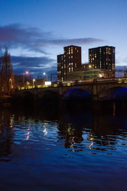 Glasgow İskoçya: 11 Şubat 2024: Mavi saat alacakaranlık sahnesi Caledonian Demiryolu Köprüsü ve nehir yatağı gece. Glasgow Merkez Demiryolu