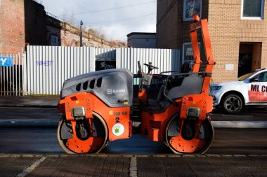 Glasgow İskoçya: 12 Şubat 2024 Güneşli bir sabah boyunca yana park etmiş bir hamm çelik davul silindiri