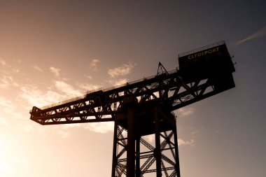 Glasgow İskoçya: 13 Şubat 2024 Finnieston Crane ve Clyde Arc güneşli bir altın saat siluetinde. Nehir kıyısında Clyde