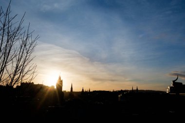 Edinburgh İskoçya: 13 Şubat 2024: Carlton Hill gözcü noktası gün batımında. Edinburgh şehrinin silueti altın saat