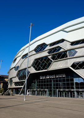 Güneşli bir günde Leeds First Direct Arena 'nın dış görünüşü girişi belirgin geometrik cephesi ve büyük cam kapılarıyla gösteriyor..
