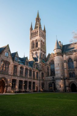 Glasgow İskoçya: 8 Ocak 2025: Glasgow Üniversitesi Gilmorehill. Gündüz vakti Glasgow 'da açık mavi gökyüzü altında bir üniversite binasının tarihi mimarisi