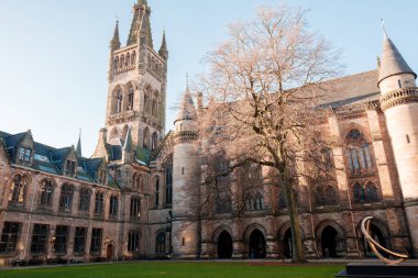 Glasgow İskoçya: 8 Ocak 2025: Glasgow Üniversitesi Gilmorehill. Gündüz vakti Glasgow 'da açık mavi gökyüzü altında bir üniversite binasının tarihi mimarisi
