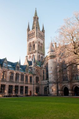 Glasgow İskoçya: 8 Ocak 2025: Glasgow Üniversitesi Gilmorehill. Gündüz vakti Glasgow 'da açık mavi gökyüzü altında bir üniversite binasının tarihi mimarisi