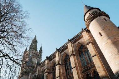 Glasgow İskoçya: 8 Ocak 2025: Glasgow Üniversitesi Gilmorehill. Gündüz vakti Glasgow 'da açık mavi gökyüzü altında bir üniversite binasının tarihi mimarisi