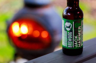 Newcastle UK: 12 Eylül 2017: Brewdog 'un orijinal dizayn edilmiş matkap IPA şişesi ateşin yanındaki masada oturuyor