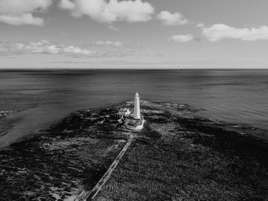 Whitley Bay UK: 13 Nisan 2025: St. Mary Deniz Feneri, açık bir günde Whitley Körfezi 'nin sakin sularına karşı yapısını gözler önüne seren bu etkileyici hava manzarasında vurgulandı