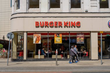 Leeds England: 2 Haziran 2024: Ziyaretçiler Leeds 'teki Boar Lane' de fast food restoranının önünden geçerken güneşli bir öğleden sonranın keyfini çıkarıyorlar.