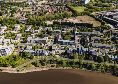 Dunston Gateshead UK: 15 Mayıs 2025: Tyne Nehri boyunca Dunston 'da yeşil peyzaj, yollar ve yakınlardaki toplulukların yer aldığı çağdaş yerleşim alanının görüntüsü. Drone pov