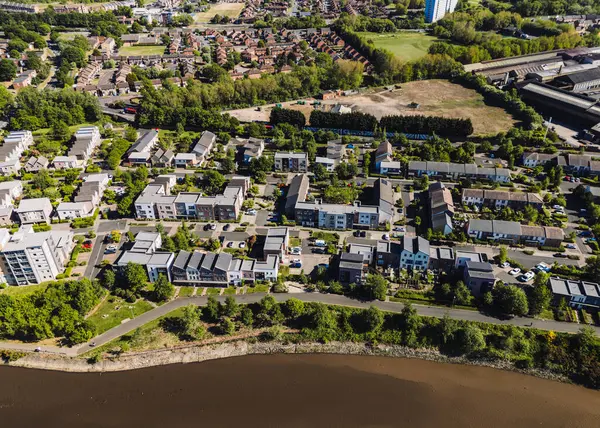 Dunston Gateshead UK: 15 Mayıs 2025: Tyne Nehri boyunca Dunston 'da yeşil peyzaj, yollar ve yakınlardaki toplulukların yer aldığı çağdaş yerleşim alanının görüntüsü. Drone pov