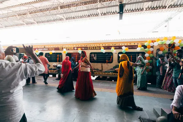 Puskhar, Hindistan. 14 Ekim 2023: Hindu kadınlar Hindistan 'da trene binmeden önce geleneksel kıyafetlerle dans ediyorlar.