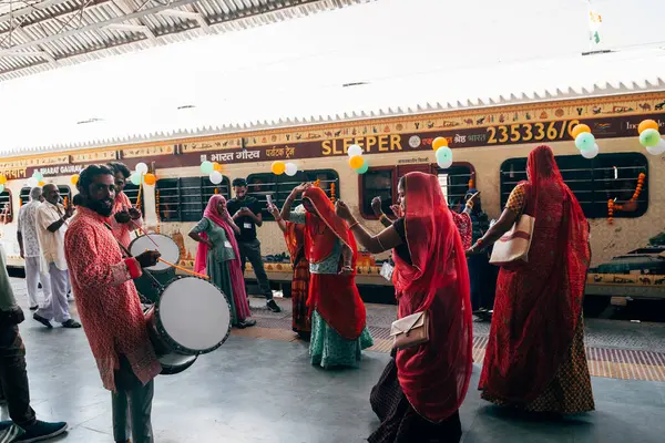 Puskhar, Hindistan. 14 Ekim 2023: Hindu kadınlar Hindistan 'da trene binmeden önce geleneksel kıyafetlerle dans ediyorlar.