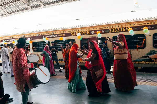 Puskhar, Hindistan. 14 Ekim 2023: Hindu kadınlar Hindistan 'da trene binmeden önce geleneksel kıyafetlerle dans ediyorlar.