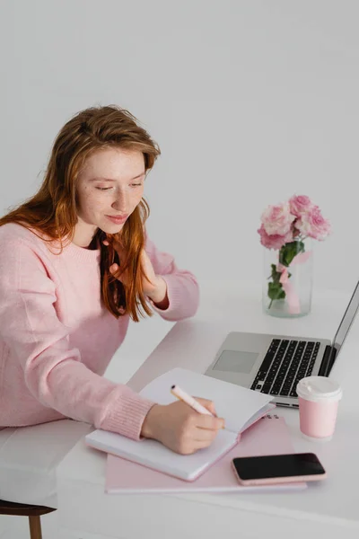 Smiling Beautiful Redhead Female Writing Notes While Sitting Table Office Stock Image