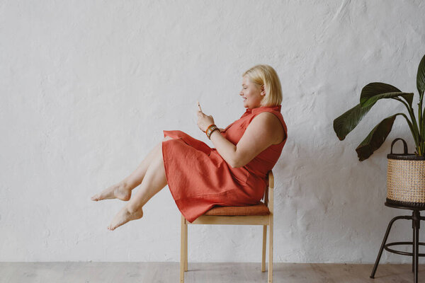 Side View Cheerful Woman Sitting Armchair Using Device Royalty Free Stock Photos