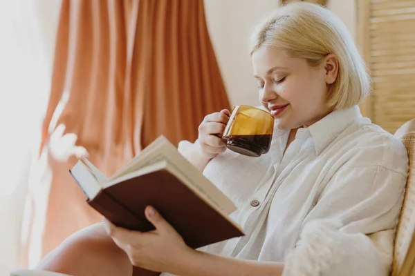 Adorable Young Blonde Woman Eyes Closed Drinking Coffee Reading Book Stock Photo