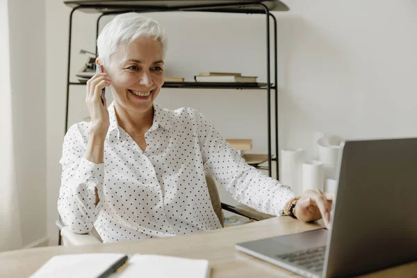 Lächelnde Elegante Grauhaarige Reife Frau Sitzt Schreibtisch Mit Laptop Und Stockbild