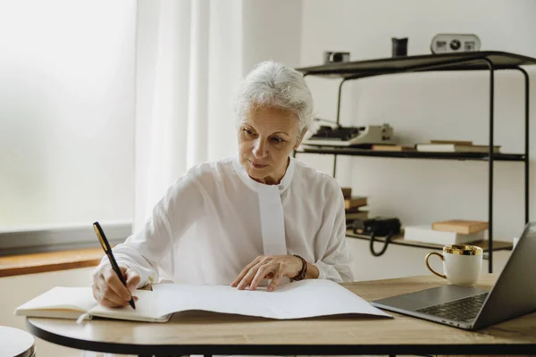 Stilvolle Grauhaarige Reife Geschäftsfrau Sitzt Mit Laptop Schreibtisch Und Macht Stockbild