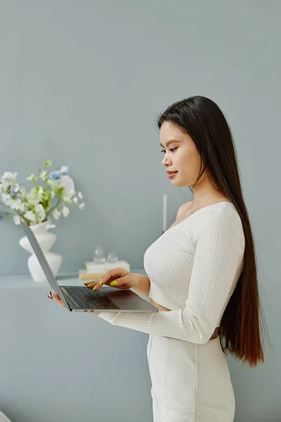 Zijaanzicht Van Jonge Langharige Aziatische Vrouw Met Behulp Van Laptop — Stockfoto