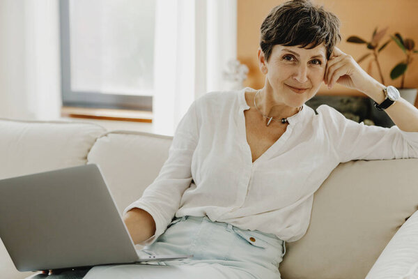 Portrait Smiling Middle Aged Woman Sitting Couch Laptop Royalty Free Stock Images
