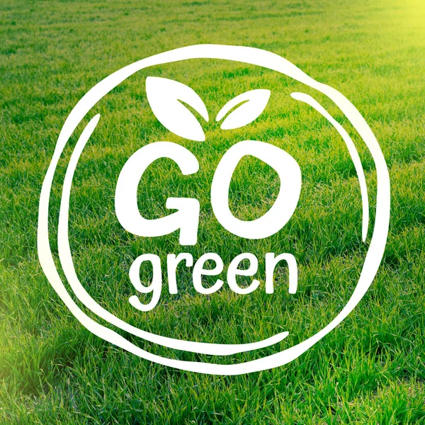 Go Green environmental protection - emblem on summer meadow background