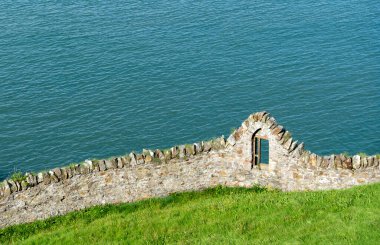 İrlanda 'daki Howth Kayalıkları' ndaki taş duvarlar, yerel taşlardan inşa edilmiş, uçurumun kenarlarından esen rüzgar, doğal güzelliğin ortasında bir tarih ve insan varlığı hissi veriyor..