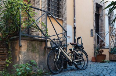 Taş kaldırımlı güzel İtalyan arka bahçesine park edilmiş bisiklet.