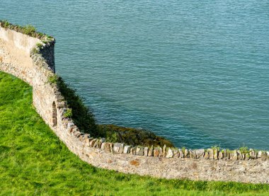 İrlanda 'daki Howth Kayalıkları' ndaki taş duvarlar, yerel taşlardan inşa edilmiş, uçurumun kenarlarından esen rüzgar, doğal güzelliğin ortasında bir tarih ve insan varlığı hissi veriyor..