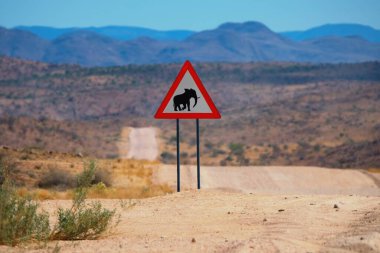 Uyarı levhası, filler caddeyi geçiyor. Namib-Naukluft Ulusal Parkı, Namibya 'daki manzara yolu. Meşhur Afrika yol gezisi yeri..