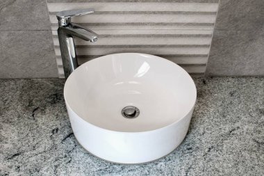 Modern beyaz yuvarlak seramik lavabo mermer banyoda..