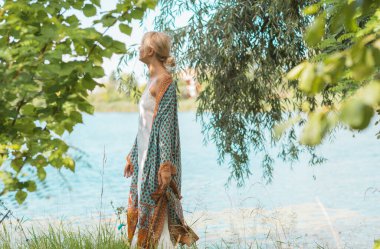 Boho, doğada çingene tarzı. Sarışın kadın açık hava portresi. Kıyafet koleksiyonu 