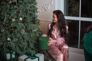 Evinde pembe, yumuşak pijamalı bir kadın. Moda tasarımı ve yaşam tarzı kavramı