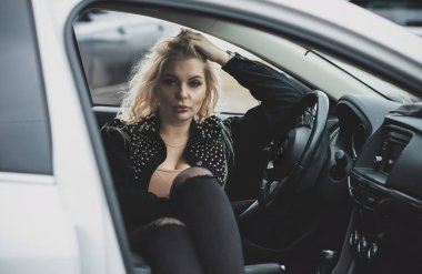 European sexy elegant woman in car, lady driving automobile, outdoors portrait. Woman on road, trip on beautiful day. Concept of women and auto