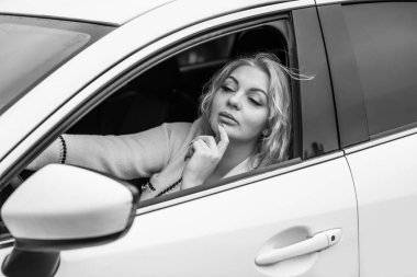 European sexy elegant woman in car, lady driving automobile, outdoors portrait. Woman on road, trip on beautiful day. Concept of women and auto