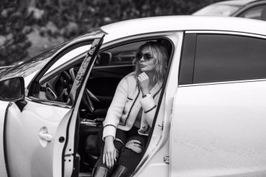 European sexy elegant woman in car, lady driving automobile, outdoors portrait. Woman on road, trip on beautiful day. Concept of women and auto