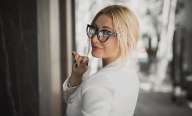Women in business style, portrait. Lady in white jacket and glasses. Outfits and modern classical trend