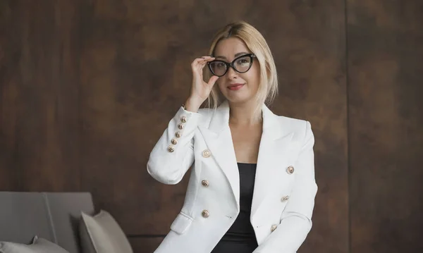 Women in business style, portrait. Lady in white jacket and glasses. Outfits and modern classical trend