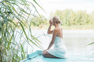 Kadınsı genç bayanın şefkatli çizimi. Beyaz ipek elbiseli romantik fotoğrafçı kadın. Kadınlar için prosedür