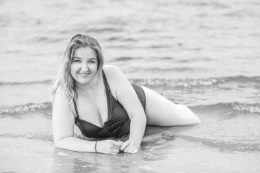 Artı mayo giymiş, suyla kaplı bir kadın. Tombul hoş bayan, vücut pozitifliği, farklı kadın ölçüleri.