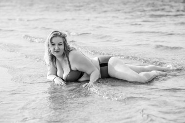 Artı mayo giymiş, suyla kaplı bir kadın. Tombul hoş bayan, vücut pozitifliği, farklı kadın ölçüleri.