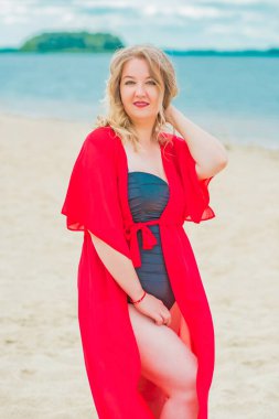 Beautiful plus size young woman rest at nature, concept of woman's life. Lady xl size having fun on a beach