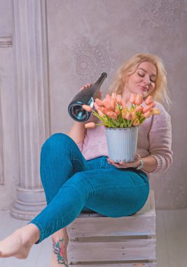 Nice happy woman celebrate with bottle of Champaign and flowers. Happy mood