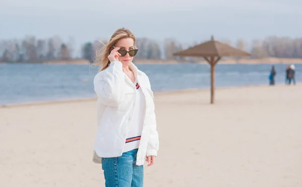 Женщина Белой Куртке Солнцезащитные Очки Синие Джинсы Пляже Новая Коллекция — стоковое фото