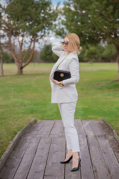 Business woman in white suit, fashionable style, outfit for work. Concept of modern lades lifestyle