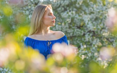 Kadınlık kavramı, akşam bahçesinde mavi elbiseli hassas modern Avrupalı kadın.