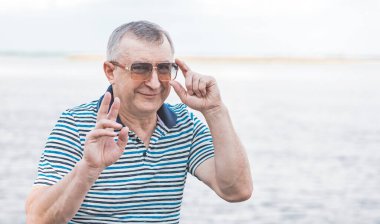 Keyfi yerinde yaşlı Avrupalı bir adam, şehir merkezinde açık hava portresi. 50-60 yıl sonra yaşam konsepti