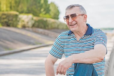 Keyfi yerinde yaşlı Avrupalı bir adam, şehir merkezinde açık hava portresi. 50-60 yıl sonra yaşam konsepti