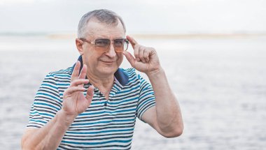 Keyfi yerinde yaşlı Avrupalı bir adam, şehir merkezinde açık hava portresi. 50-60 yıl sonra yaşam konsepti